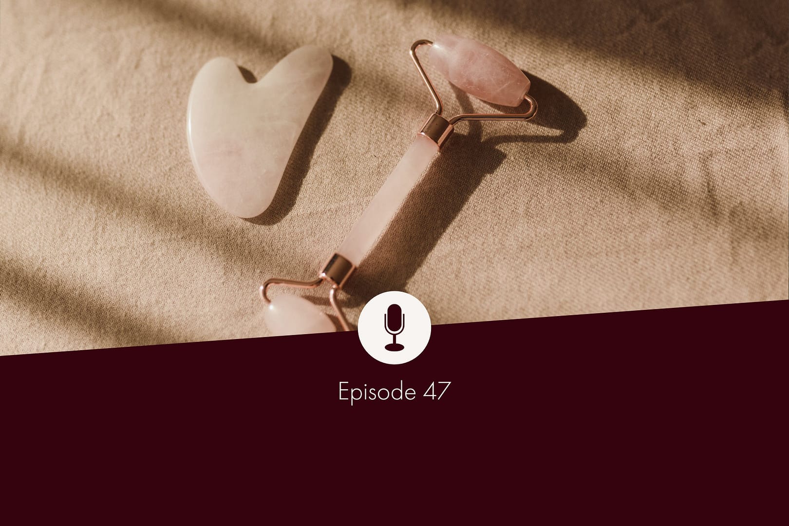 Photo of Gua Sha roller and Gua Sha stone (Chinese facial massage accessories) made of rose quartz on a beige linen cloth
